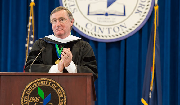 Retired Major General Fergal I. Foley applauds the 2019 SUNY Canton graduating class.