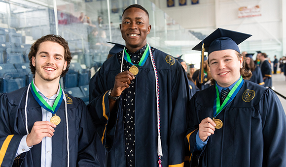 Three students show off their SUNY Canton medallions before Commencement 2022.