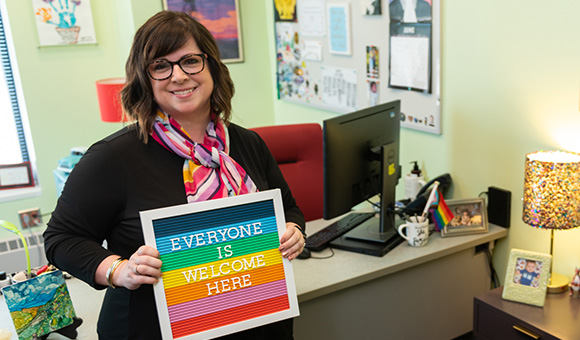 Courtney Bish holding an Everyone is Welcome Here sign