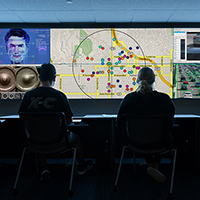 Students sit in front of multiple screens tracking a crime scene.