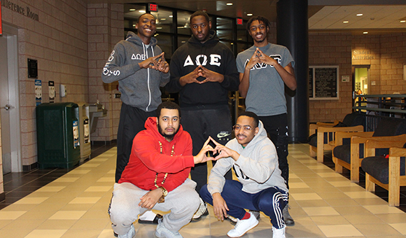 Delta Omega Epsilon Fraternity poses in the Miller Campus Center atrium.