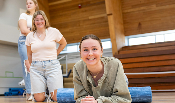 Olivia Plonka, Emerson Garrow and Madison Carista practice exercises with a foam roller as part of the Health and Fitness Promotion program demonstration.