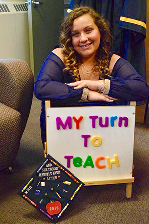 A student holds a sign that says, 