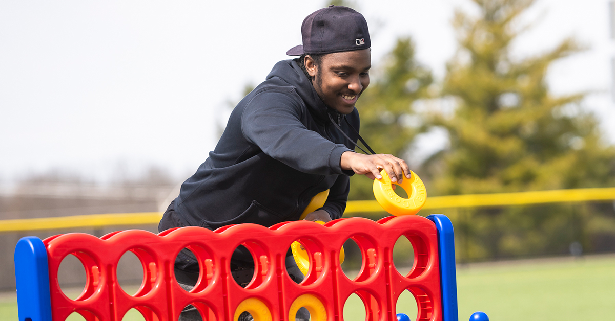 A student adds a yellow token during a giant game of Connect Four.