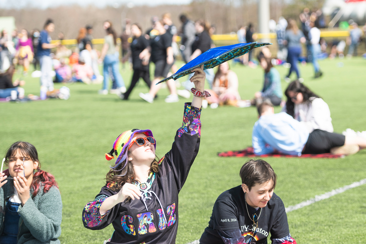 A student holds up a star shaped umbrella before the start of the eclipse.