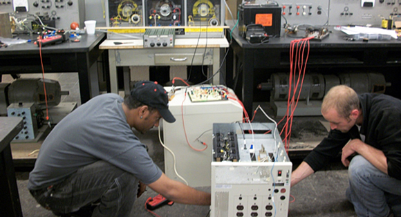 Two students work on a senior electrical project.