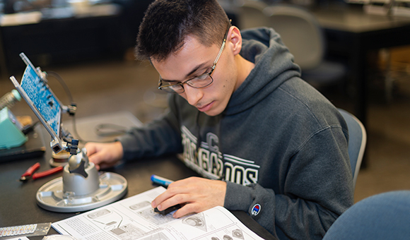 A student studies and works in the Electrical Technology lab.