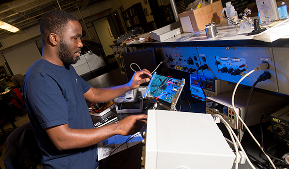 A student tests a motherboard in the Electrical Engineering lab.