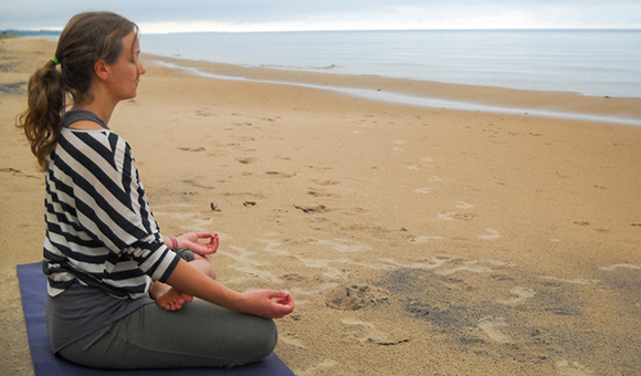 Erica Sharpe practices yoga on a beach.