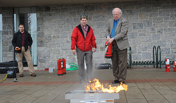 President Szafran puts out a fire with an extinguisher.