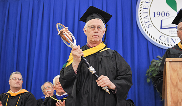 Daniel Fay carrying the College mace during Commencement.