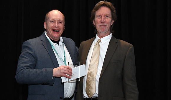Charles Fenner receives 2023 Business Faculty of the Year award from International Accreditation Council for Business Education President Patrick Hafford.