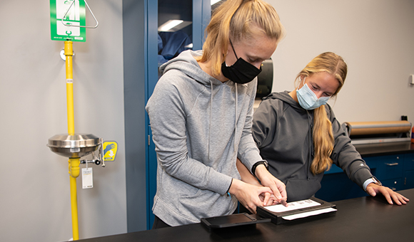 Alexandria Mikula and Rachel Merica practice taking fingerprints during a class.