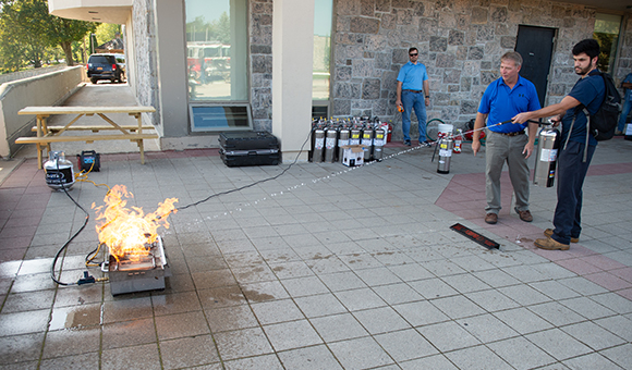 Environmental Health and Safety provide students fire extinguisher training in the plaza.