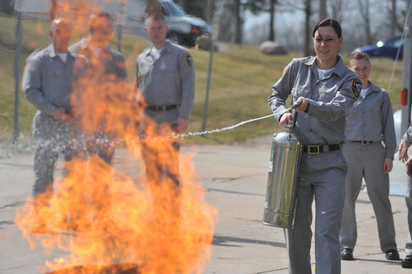 A cadet puts out a fire.