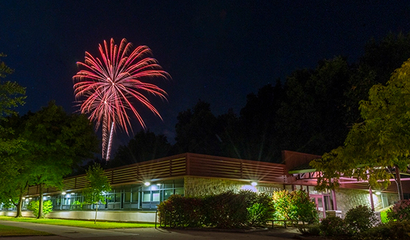 Red fireworks burst over Nevaldine Hall during Fall Fest 2024.