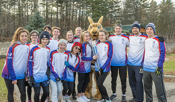 Roody joins SUNY Canton athletes and students from Canton High School at the entrance of the footbridges before running the FISU torch into campus.