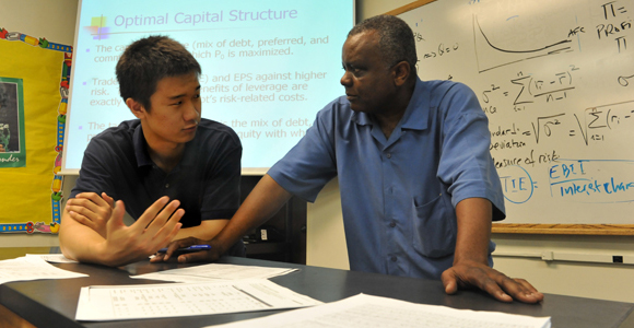 A student discusses an assignment with Dr. Edouard Mafoua.