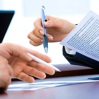 Two hands holding pens in an office.
