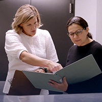 Two administrators compare medical coding notes.