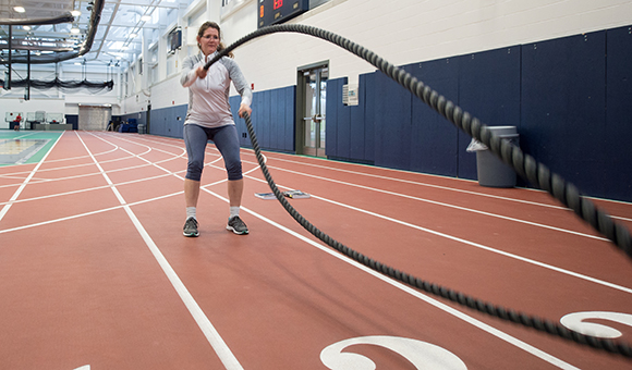 A student does rope exercises in the Field House