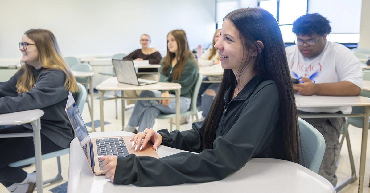 Students on laptops engage in a marketing course.