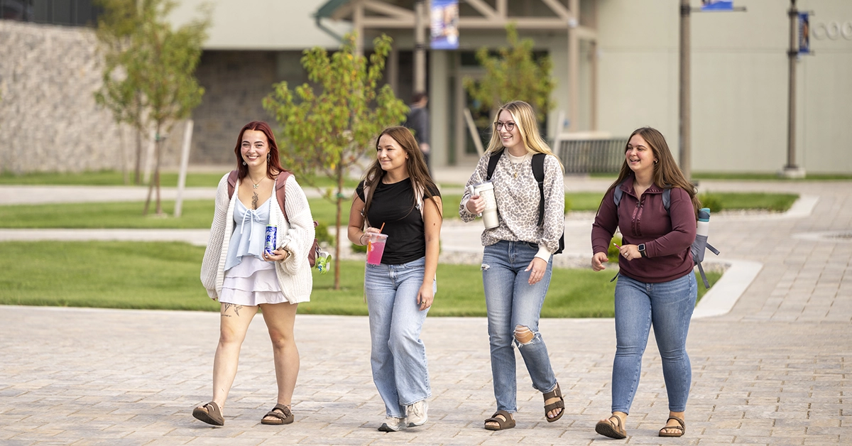 Four students walk through the new Roselle Plaza during the first day of fall classes.