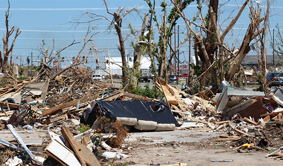 Aftermath of a hurricane with mattresses and other remains littering an urban neighborhood.