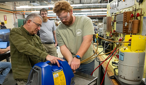 Lecturer Jay Simmons helps students Harold Bush and Devin Green.