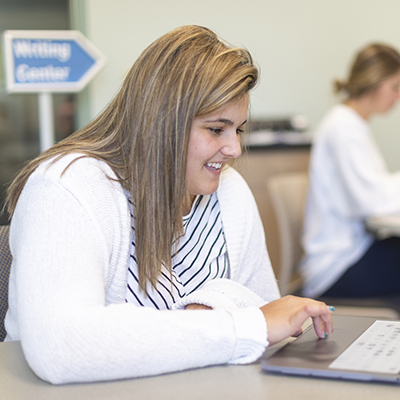 A student works on a laptop at the library.