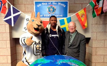 Roody, a student, and President Szafran pose behind a large globe