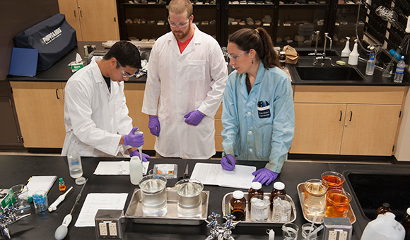 Professor Adrienne Rygel assists two students in the water filtration laboratory.