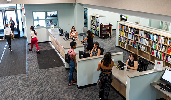 Patrons visit the front desk at the Southworth Library Learning Commons