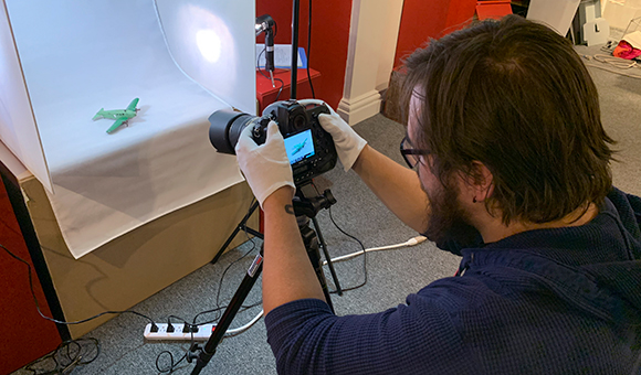 Logan Coggins takes a photo of one of the artifacts used in a History of a North Country Childhood which is currently on display at the North Country Children’s Museum