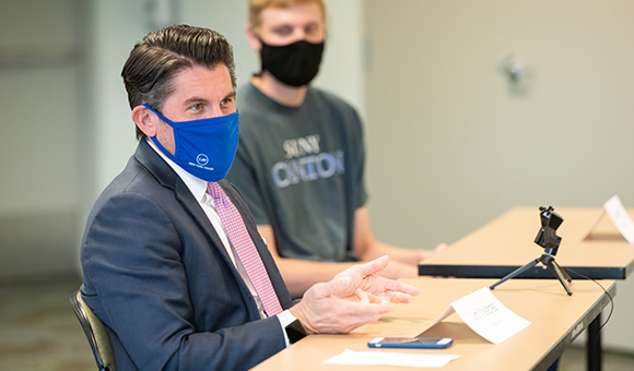 SUNY Chancellor Jim Malatras speaks while student leader Andrew Fitch looks on.