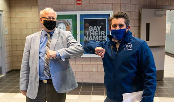 President Zvi Szafran and SUNY Chancellor Jim Malatras exchange elbow bumps.