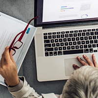 A person types medical codes on a laptop.