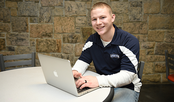 A veteran student types on a laptop.