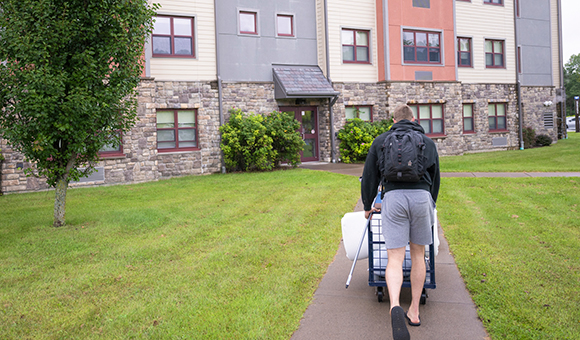 A student moves belongings into Kennedy Hall.