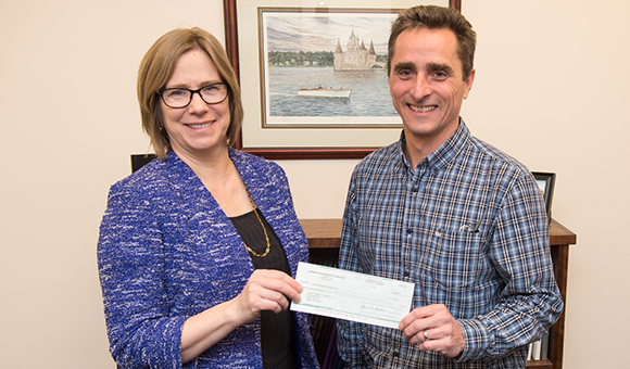 Anne Sibley and Bart Tuttle hold a check from Corning Incorporated Foundation.