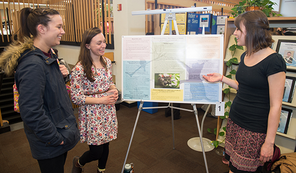 Jessen Swider and Courtney Cotter showcase their research on stray felines in the Southworth Library.