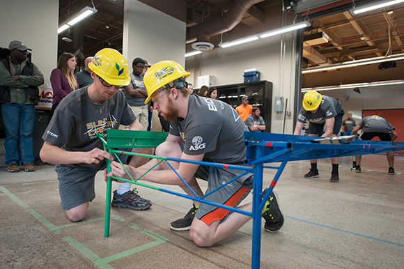 Steel bridge team member assemble the bridge in a practice run.