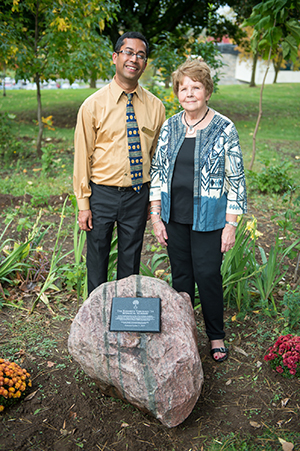 Rajiv Narula and Barbara Rich Wilder pose in front of the Theobald memorial rock.
