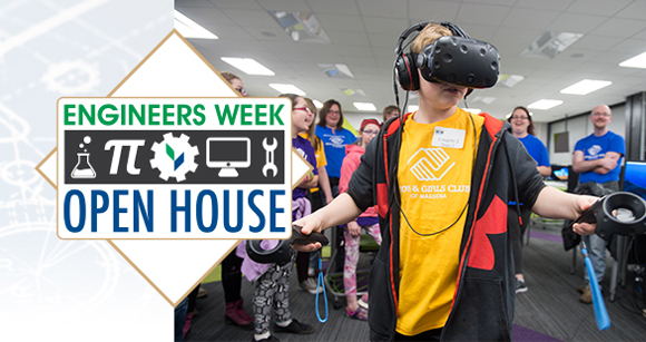 Engineers Week Open House - Student using VR goggles while other students look on.
