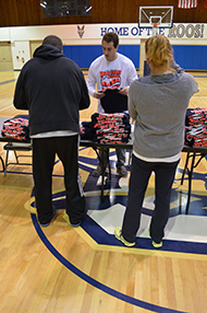 Students hand out t-shirts to the runners.