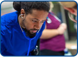 A nursing student uses a stethoscope to check a heartbeat.