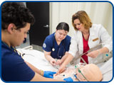 Two nursing students work with faculty member Leah Payne-Worden.