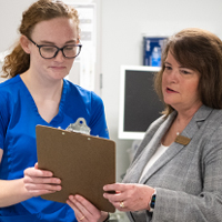 A nurse works with an administrator in a nursing home.