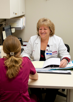 A supervisor meets with another nurse.