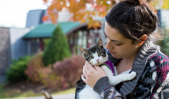 A student holds her pet cat outside the residence halls.